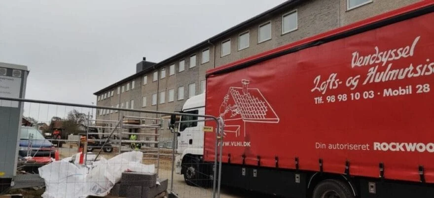 Byggeplads med lastbil og bygning