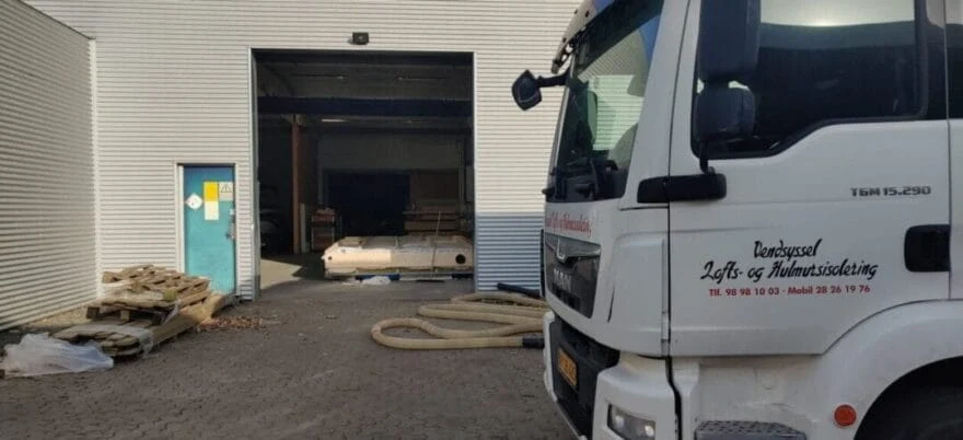 Lastbil foran garage med materialer
