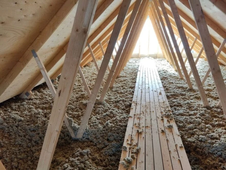 Loft med træbjælker og isolering.