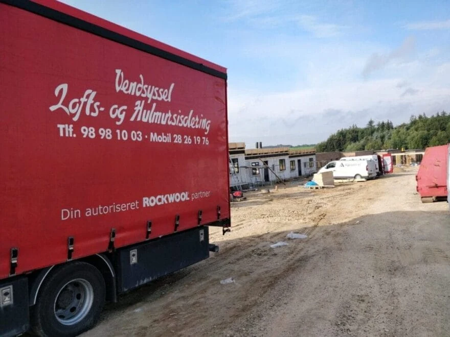 Byggeplads med lastbil og materialer